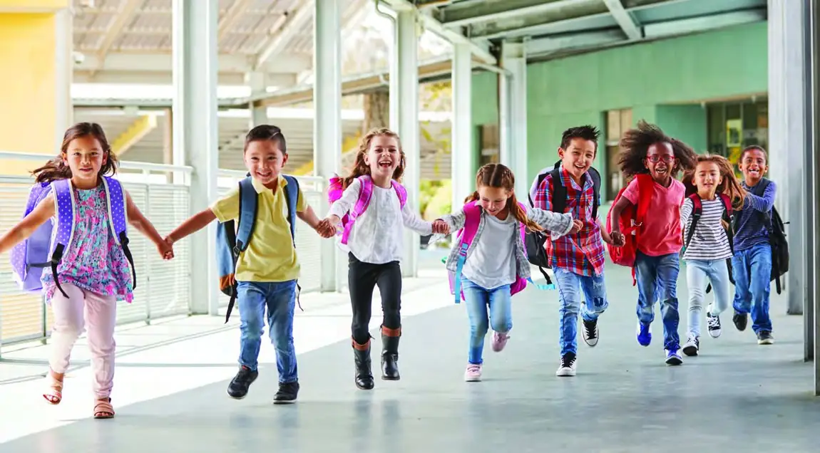 Elementary students running and laughing together outside their Richmond school.
