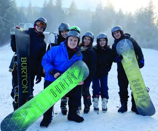 Students holding snowboards on a ski hill near Richmond.
